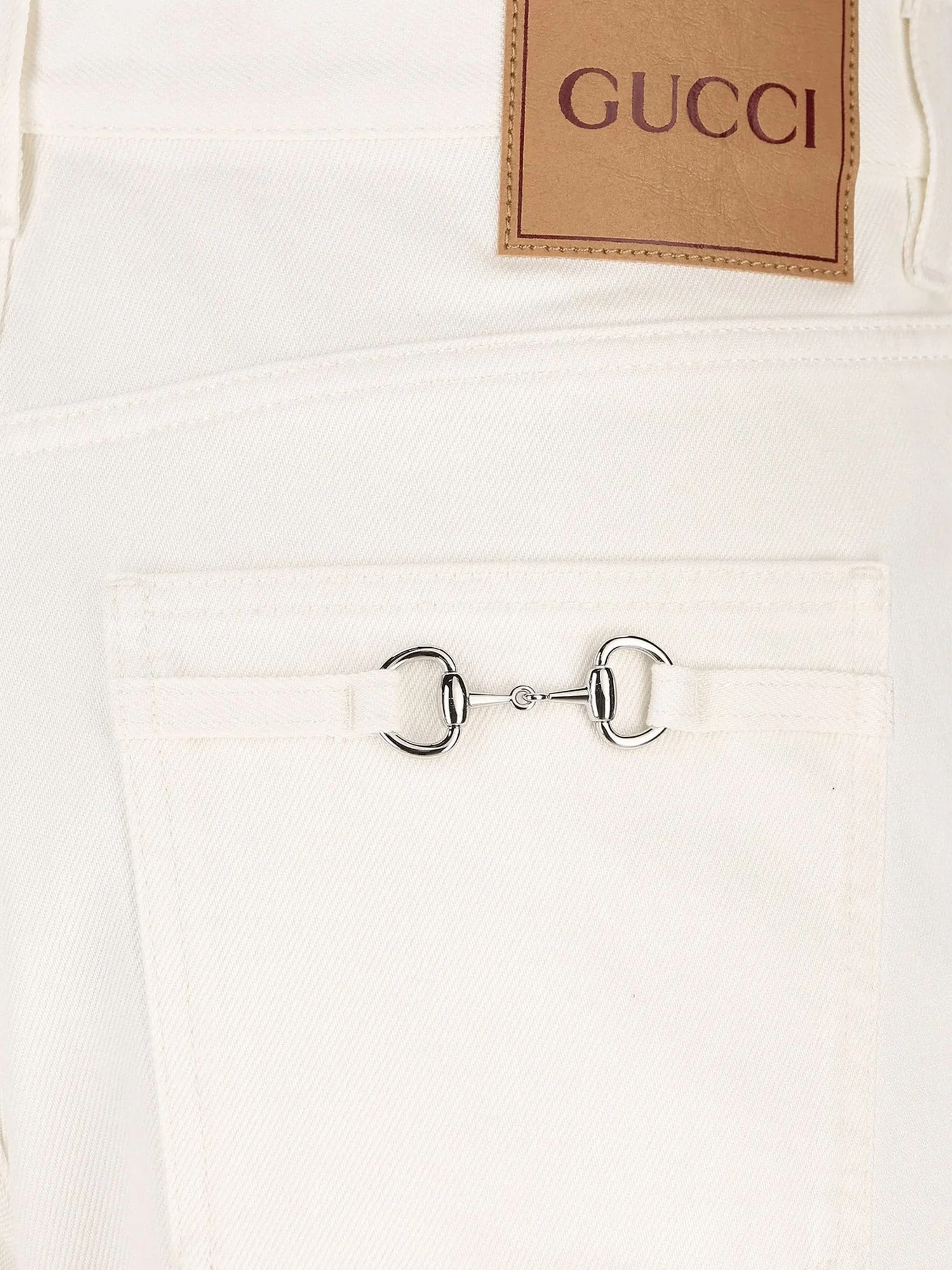 Denim trousers with metal Horsebit detail on the back.webp