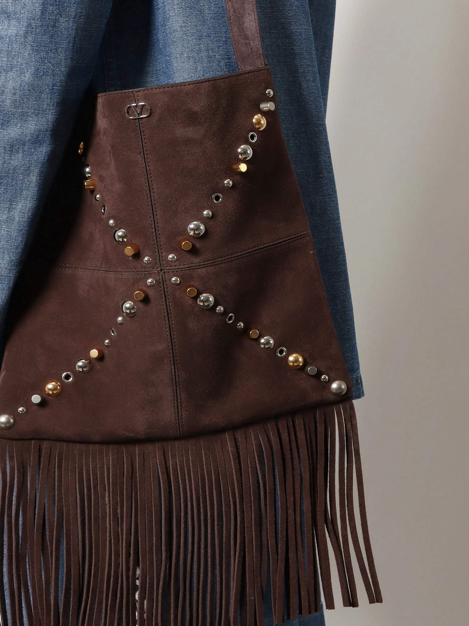 Suede shoulder bag with fringes and metal details.webp