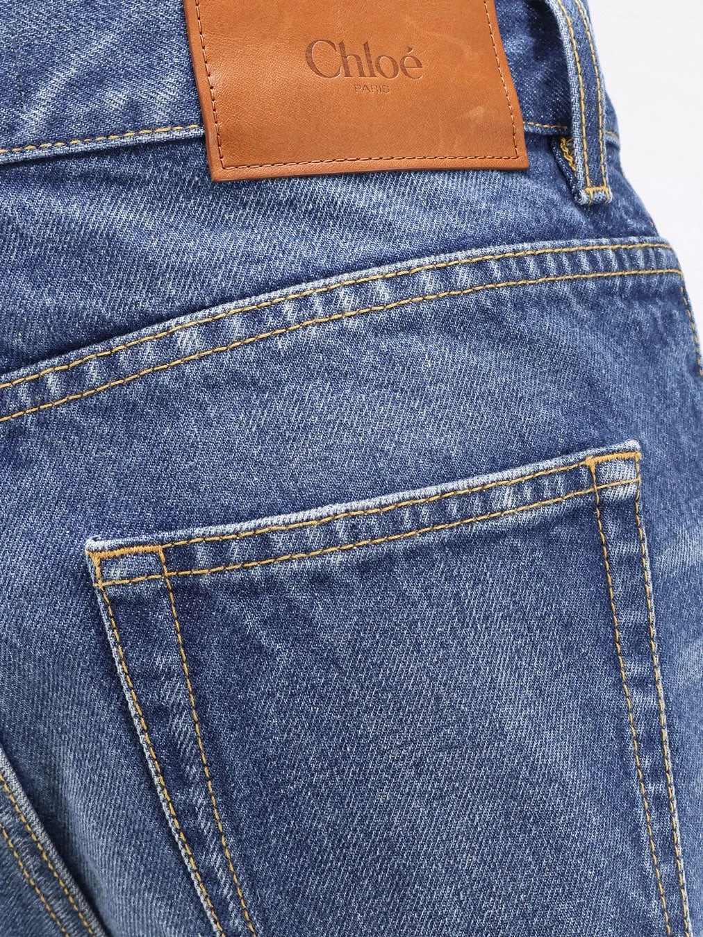 Jeans with leather logo tag.webp