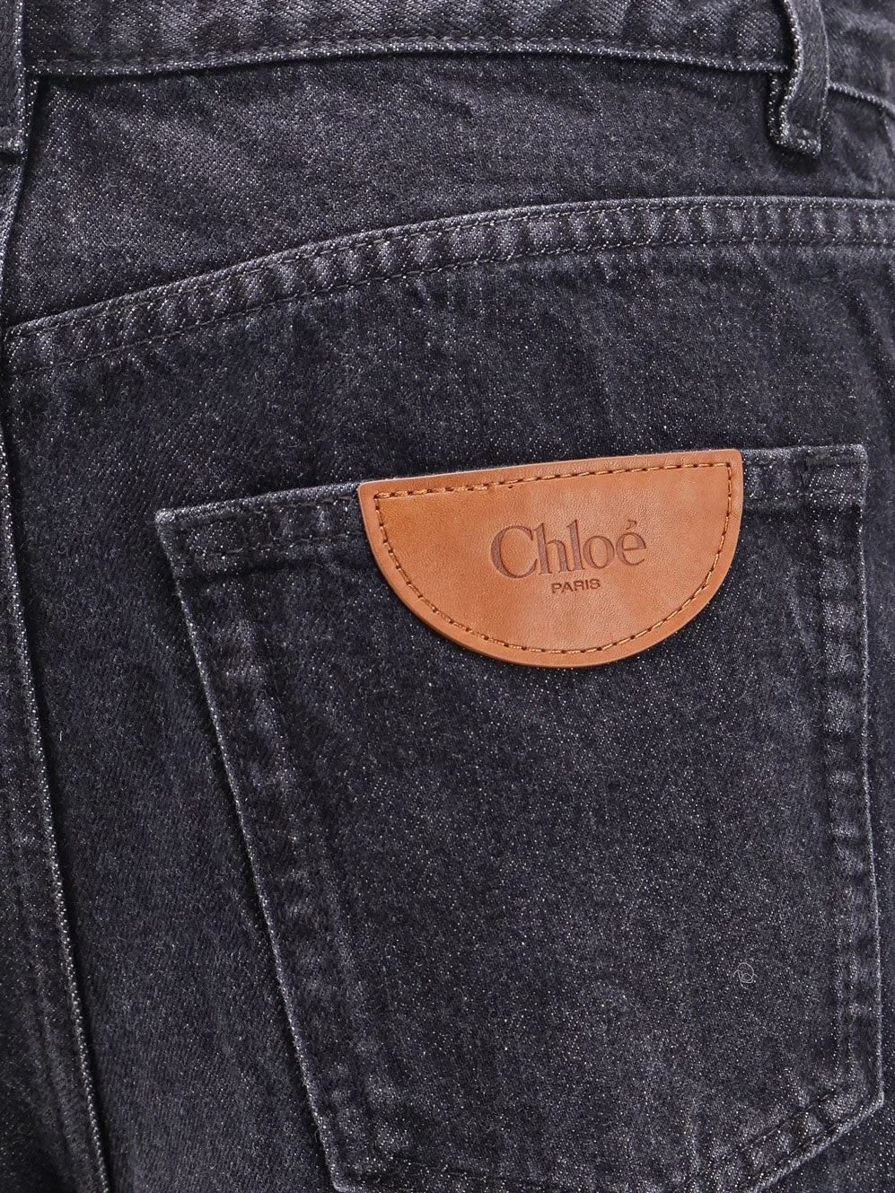 Jeans with iconic leather logo tag.webp