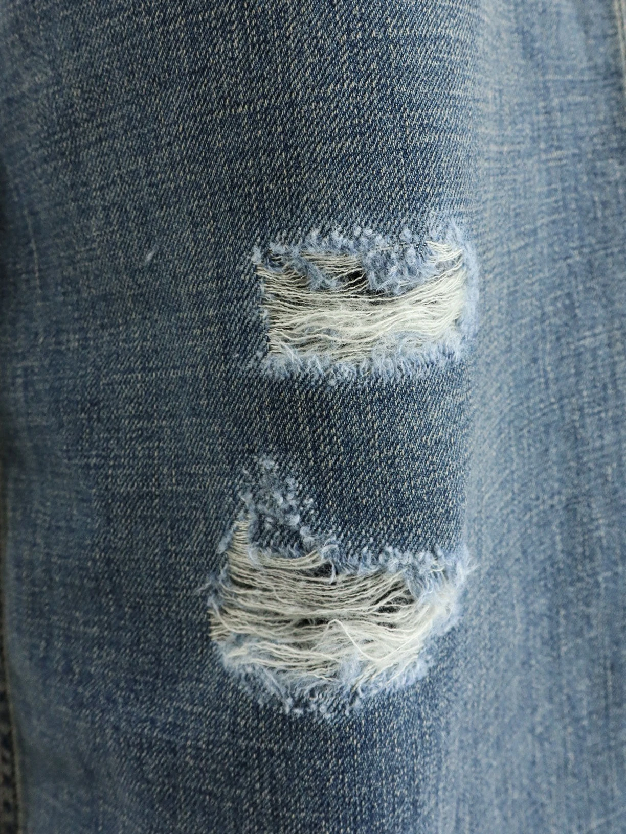 Destroyed-effect blue denim jeans.webp